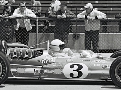 Gordon Johncock in his #3 Gilmour Broadcasting Gerhardt at the 1967 Indy 500. The Dzus fasteners are still visible in this picture.  Part of the Dave Friedman collection. Licenced by The Henry Ford under Creative Commons licence Attribution-NonCommercial-NoDerivs 2.0 Generic. Original image has been cropped.