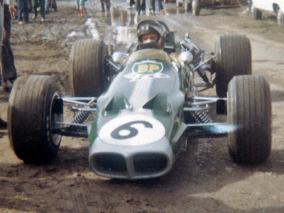 Graham Hill in the mud of the paddock at the 1969 Albi Grand Prix in his Lotus 59B. Copyright Gerard Barathieu 2020. Used with permission.
