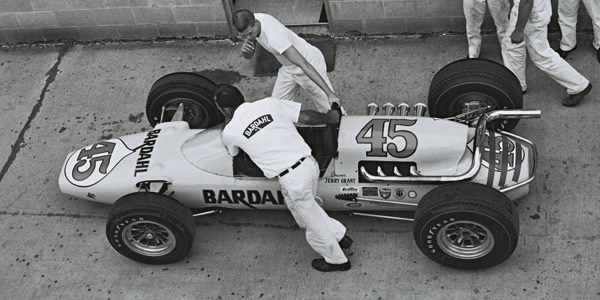 Jerry Grant's #45 Gerhardt is pushed to the track at Indianapolis in 1964 by Harry Salwasser (bottom) and a young Dennis Johansen (top). Part of the Dave Friedman collection. Licenced by The Henry Ford under Creative Commons licence Attribution-NonCommercial-NoDerivs 2.0 Generic. Original image has been cropped.