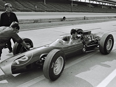 David Lazenby pushes Jim Clark's Lotus 29 into position as Colin Riley steers and Colin Chapman supervises.  Part of the Dave Friedman collection. Licenced by The Henry Ford under Creative Commons licence Attribution-NonCommercial-NoDerivs 2.0 Generic. Original image has been cropped.