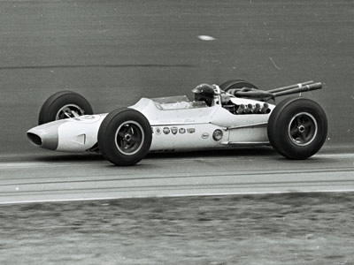 Dan Gurney in the #12 Lotus 34 at the 1964 Indy 500. Part of the Dave Friedman collection. Licenced by The Henry Ford under Creative Commons licence Attribution-NonCommercial-NoDerivs 2.0 Generic. Original image has been cropped.