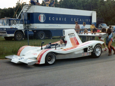 Dwight Zillig's crew pushes his Can-Am Lola T330 through the paddock at the Road America Can-Am race in July 1978. Copyright Jay Tiede 2020. Used with permission.
