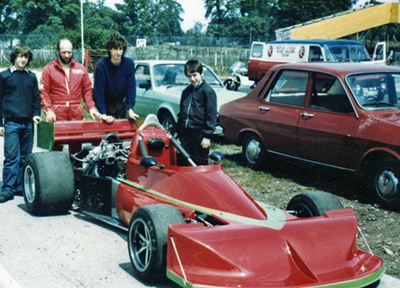 John Holmes with his March 772P-Rover turbo and his team, believed to be at a test session at Oulton Park in 1984. Copyright David Tuck 2021. Used with permission. John Holmes with his March 772P-Rover turbo and his team, believed to be at a test session at Oulton Park in 1984. Copyright David Tuck 2021. Used with permission.