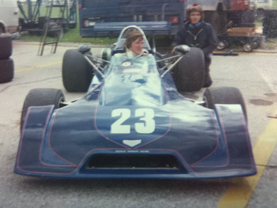 Chip Mead in his Chevron B27 at Gimli in 1974.  At the rear wheel is mechanic Keith "Wombat" Devereux. Copyright Brian Williams 2020. Used with permission.